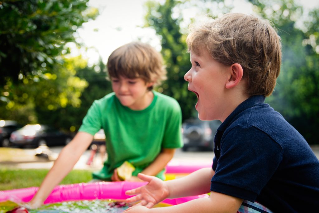 Dois meninos crianças brincando a céu aberto.