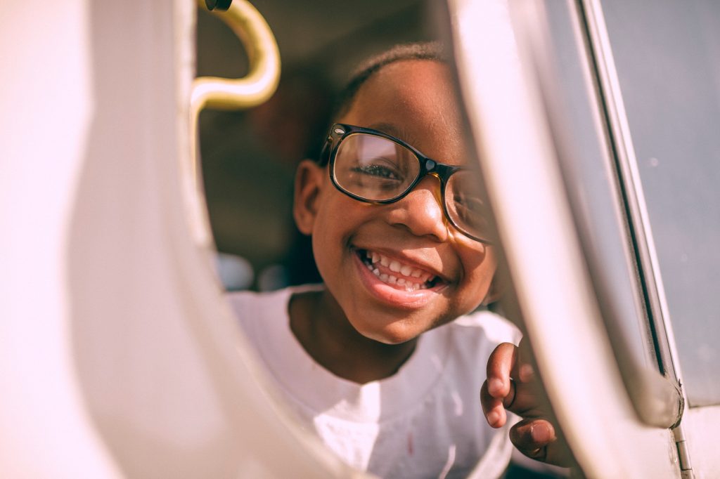 Menino criança sorrindo para a câmera.