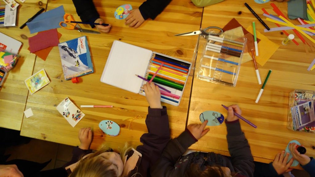 Visão de cima de uma mesa onde crianção estão aprendendo o que é DIY.